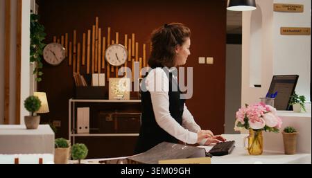 Ein vielfältiges Personal half der alten Frau beim Check-in und begrüßte die Gäste im 5-Sterne-Hotel. Pagenladen, der Gepäck für Rentner trägt und exzellenten Concierge-Service bietet. Stockfoto