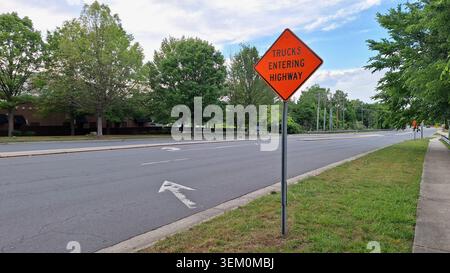 Das Foto zeigt ein Straßenschild, das den Fahrer auf den bevorstehenden Lkw-Verkehr aufmerksam macht. Das Schild konzentriert sich auf die Sicherheit und das Bewusstsein im Straßenverkehr. Stockfoto