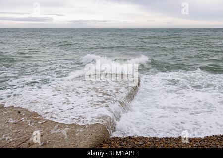 Wellen plätschern auf einem Breakwater Groyne Stockfoto