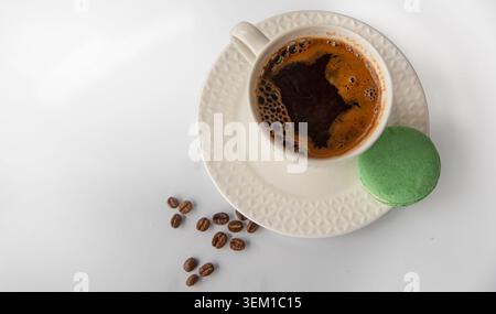 Weiße Kaffeetasse Mit Grünem Macaron Und Kaffeebohnen Auf Hintergrund Stockfoto
