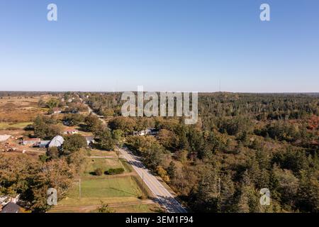 Blick auf die Drohne aus der Vogelperspektive auf einer Landstraße durch Wälder in der Nähe von Yarmouth Nova Scotia Kanada mit herbstlichen Bäumen, Landschaften und klaren Bäumen Stockfoto