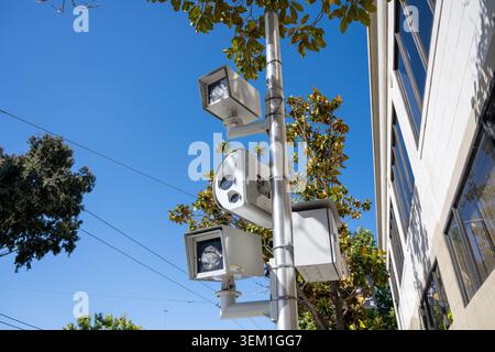 Verkehrs- und Überwachungskameras montiert auf Metallpfosten neben Gebäuden und Bäumen unter klarem blauem Himmel, San Francisco, Kalifornien, 14. Mai 2026. (Foto: Smith Collection/Gado/SIPA USA) Stockfoto