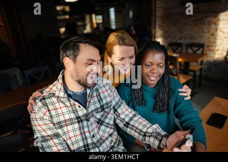 Verschiedene Freunde genießen die Zeit im Restaurant mit dem Smartphone Stockfoto