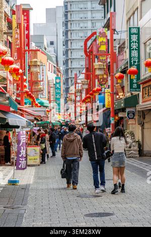Fußgänger schlendern entlang einer von Laternen gesäumten Einkaufsstraße in Nankinmachi Chinatown, Kobe, Japan Stockfoto
