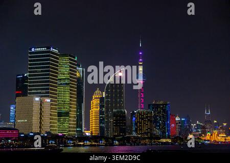 Beleuchtete Skyline von Pudong mit orientalischem Perlturm, der nachts rosa leuchtet, über dem Huangpu River, Shanghai, China Stockfoto