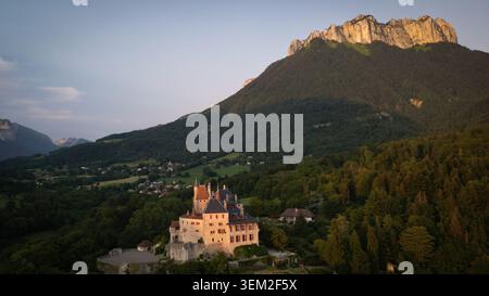 Menthon-Saint-Bernard, Frankreich - 09. Juli 2023: Aus der Vogelperspektive auf das Schloss Menthon-Saint-Bernard mit seinen Steintürmen und Dächern, die sich an einem bac schmiegen Stockfoto