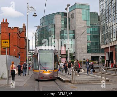 Luas Red Line Straßenbahn an der Haltestelle Jervis an der Abbey Street Upper in Dublin 1, Irland, mit Gebäuden des Stadtzentrums im Hintergrund. Stockfoto