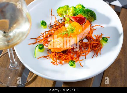 Gebratener Lachs mit geräucherter Julienne-Karotte, Brokkoli, Gurke, Feigen Stockfoto