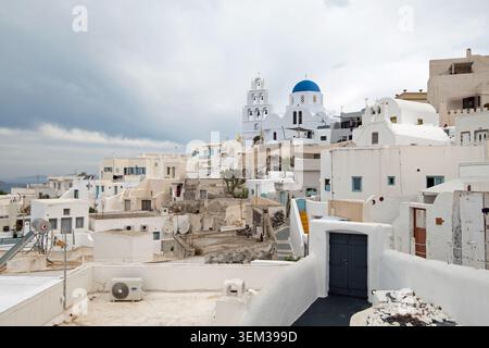 Panoramablick auf Pyrgis in Santorin mit traditionellen weißen Häusern und blauer Kuppelkirche auf dem Hügel Stockfoto