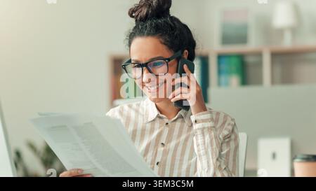 Lächelnde Junge Hispanische Frau, Die Auf Dem Smartphone Spricht, Während Sie Dokumente Im Büro Liest, Geschäftskonzept Stockfoto