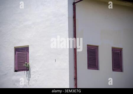 Traditionelle Fensterläden aus Holz an der weißen Kolonialfassade von Fort Rotterdam, Makassar, Süd-Sulawesi, Indonesien. Stockfoto