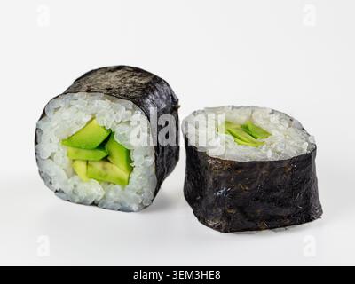 Nahaufnahme von zwei frischen Avocado-Maki-Sushi-Rollen isoliert auf weißem Hintergrund. Minimalistisches Studio mit hellen Lichtern in Grün, weiß und blau Stockfoto