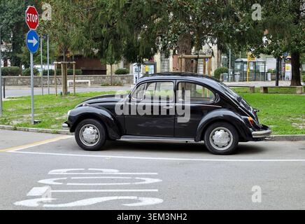 Ronchi dei Legionari, Italien. November 2023. Vintage-schwarzer Volkswagen Käfer oder Typ 1 in einer Stadtstraße. Seitenansicht. Stockfoto
