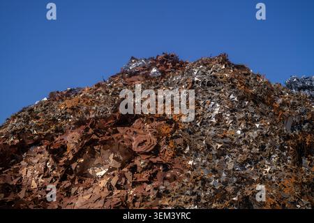 Schrotthaufen von Schrott im Schrottplatz mit verschiedenen rostigen Komponenten, Metallspänen und weggeworfenen Maschinen Stockfoto