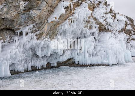 Winterlandschaft mit eisbedeckten Küstenfelsen mit hängenden Eiszapfen und gefrorenem Spray auf der Insel Kharantsy, dem Baikalsee, der Oblast Irkutsk, Russland, der kalten nat Stockfoto