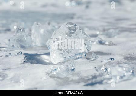Nahaufnahme von transparenten Eisstücken auf der gefrorenen Oberfläche des Baikalsees im Winter, Russland. Natürlicher kalter Hintergrund mit glitzernden Highlights und Kopie Stockfoto