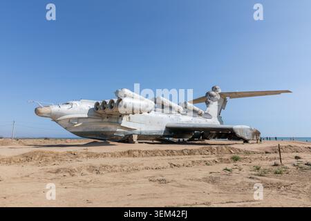 Die verlassene LUN Klasse ekranoplan, ein sowjetisches Bodeneffektfahrzeug, steht an der Sandküste nahe Derbent, Dagestan, Russland unter klarem blauem Himmel, reisen Stockfoto
