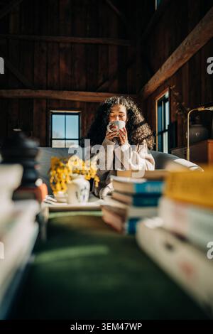 Frau genießt Morgenkaffee in einer rustikalen Hütte Stockfoto