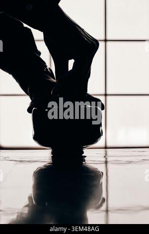 Silhouette eines Hand rauschenden grünen Tees in Japan Stockfoto