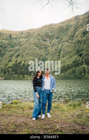 Lächelndes Paar, das an einer Bergsee-Landschaft steht Stockfoto