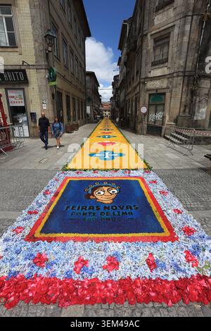 Ponte de Lima, Portugal - 4. Juni 2026: Besucher bewundern die komplizierten Sägemehl- und Blumenteppiche entlang der engen historischen Gassen von Ponte de Lima f Stockfoto