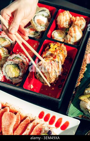 Leute in einer Sushi-Bar essen Sushi mit Essstäbchen. Stockfoto