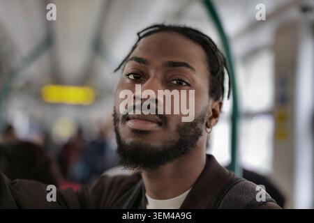 Der junge Schwarze schaut in die Kamera im öffentlichen Nahverkehr Stockfoto