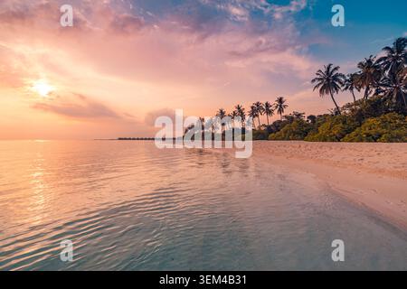 Goldener Sonnenuntergang über einem tropischen Inselstrand, Palmen an einem ruhigen Ufer, die Sonne glüht über dem ruhigen Meer, warme abendliche Sommerküstenlandschaft, malerisch. Reisen Stockfoto