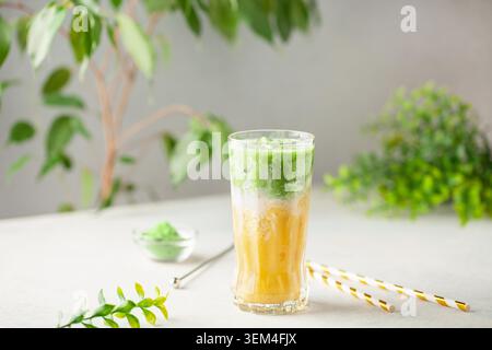 Eis Mango Matcha Latte im Glas auf dem Tisch Stockfoto