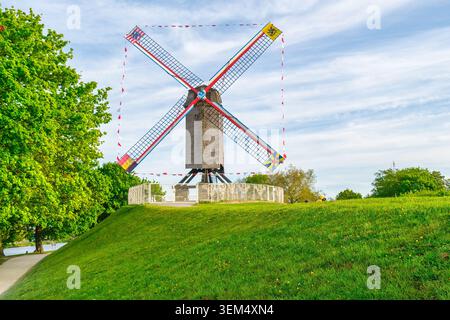 Historische Windmühlen säumen die alten Stadtmauern von Brügge während der goldenen Stunde und zeigen die traditionelle flämische Landschaft und den mittelalterlichen Charme Belgiens. I Stockfoto