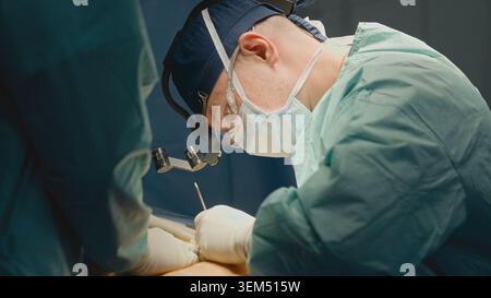 Zwei Fachärzte Chirurgen operieren Patienten mit präzisem Schnitt mit Skalpell in der sterilen Klinik der modernen Medizin Therapie des Magenabdominals Stockfoto
