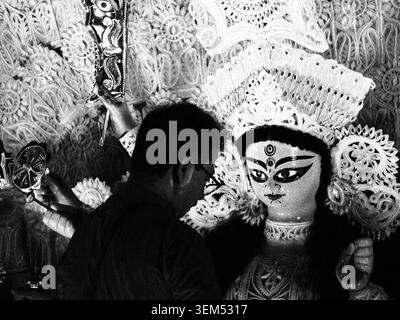 Ein Mann, der an einem Göttin Durga-Idol arbeitet, vor den Durga-Puja-Feiern in Delhi, Indien. Schwarzweiß-Dokumentarfoto der Bengalischen Kultur. Stockfoto