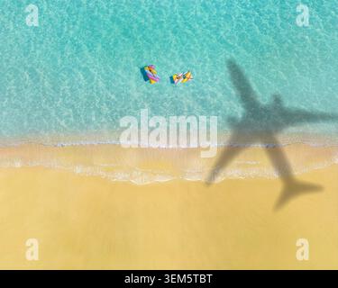 Wellen am Strand mit Schatten von kommerziellen Flugzeugen, die über dem wunderschönen tropischen Strand fliegen Stockfoto