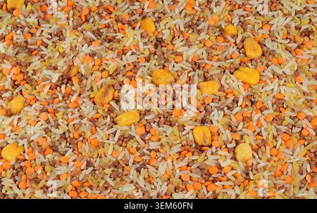 Blick von oben auf eine bunte gesunde Mischung aus weißem Reis, Buchweizenkörnern, roten Linsen und knusprigen Maispuffs. Stockfoto