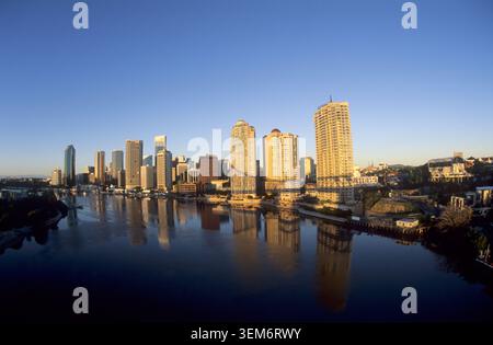 Panoramische Weitwinkelaufnahme der Skyline von Brisbane, die sich im Brisbane River bei Sonnenaufgang spiegelt, Brisbane, Queensland, Australien. Stockfoto