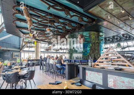 Memphis, Vereinigte Staaten, 23. MAI 2026 – Gäste sitzen an einer Theke in einem Restaurant mit einem großen zylindrischen Aquarium und aufwendiger Mechanik Stockfoto