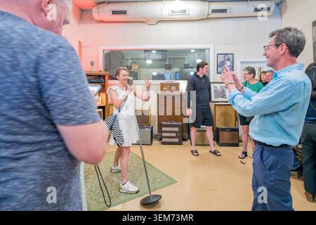 Memphis, Tennessee, Vereinigte Staaten, 24. Mai 2026 – Eine Frau singt in ein Retro-Mikrofon, während Besucher im Sun Studio Aufnahmen machen Stockfoto