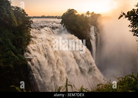 Victoria Falls bei Sonnenaufgang, Zambezi River Schlucht vom Rand in Simbabwe Stockfoto