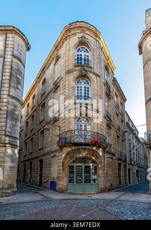 Ein wunderschönes Eckgebäude aus Stein mit Bogenfenstern, kunstvollen schmiedeeisernen Balkonen und einem geschwungenen Eingang, Bordeaux Altstadt, Frankreich Stockfoto