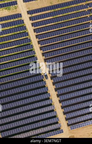 Luftaufnahme eines Autos zwischen ausgedehnten Reihen von Solarpaneelen, Agri PV, Deutschland Stockfoto