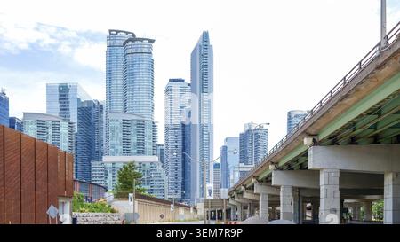 Toronto ON, Kanada - 04. Juli 2022: Urbane Skyline mit beeindruckenden Wolkenkratzern und einer Autobahnüberführung, die die moderne Architektur und die Stadt beleuchtet Stockfoto