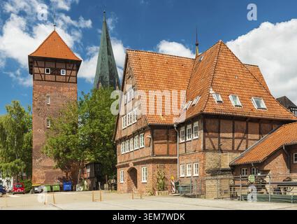 Lüneburg - Juli 2018, Deutschland: Historische Gebäude im traditionellen deutschen Stil. Altes Haus und Turm aus rotem Backstein auf einer Straße mit Stockfoto