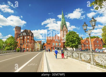 Luneburg - Juli 2018, Deutschland: Zwei Frauen laufen auf der Brücke über den Fluss. Stadtbild einer alten europäischen Stadt mit traditioneller Architektur Stockfoto