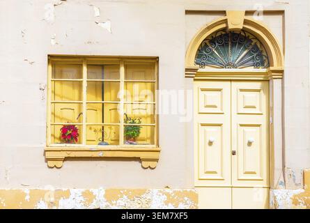 Fassade eines alten gelben Wohngebäudes mit abblätternder Farbe Stockfoto