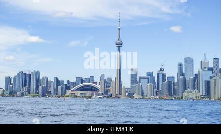 Toronto ON, Kanada - 03. Juli 2022: Blick auf die Skyline von Toronto mit CN Tower und Rogers Centre mit leuchtendem blauem Himmel und Wasserreflexionen Stockfoto