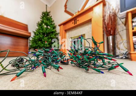Künstlicher Weihnachtsbaum, der in einem Wohnzimmer mit Feenlichtern steht und während der Weihnachtszeit dekoriert werden kann Stockfoto