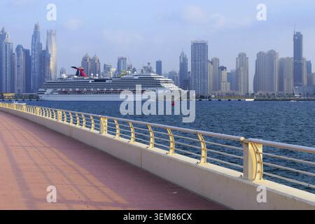 Die Szene fängt die Kreuzung aus moderner Seefahrt und urbaner Architektur ein und zeigt elegante Wolkenkratzer, die sich auf ruhigem Wasser spiegeln. Ein gepflasterter Stockfoto