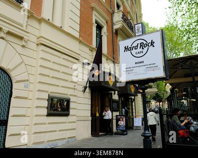 Außenschild am Eingang in der Nähe des Bürgersteigs, Terrasse, Abendessen und Tische im Hard Rock Cafe an der Via Veneto in Roma, Italien; Restaurants und Restaurants. Stockfoto
