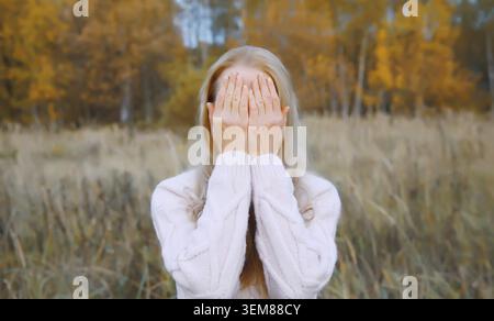 Verärgert traurig schreiende junge Frau bedeckt ihre Augen und ihr Gesicht mit ihren Händen, während sie Depressionen, Stress, Müdigkeit und geistiges Leid im Autu erlebt Stockfoto