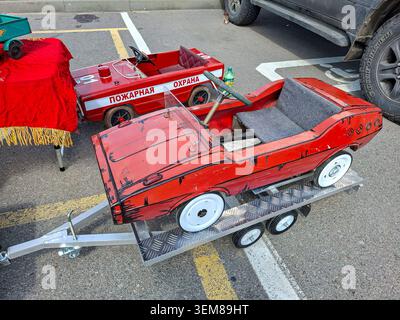 WORONESCH, Russland - 25. April 2026. Zwei rote, alte sowjetische Kinderpedalwagen parken auf einem Wohnwagen auf einer Freiluftausstellung. Ein Auto ist ein Pozharna Stockfoto